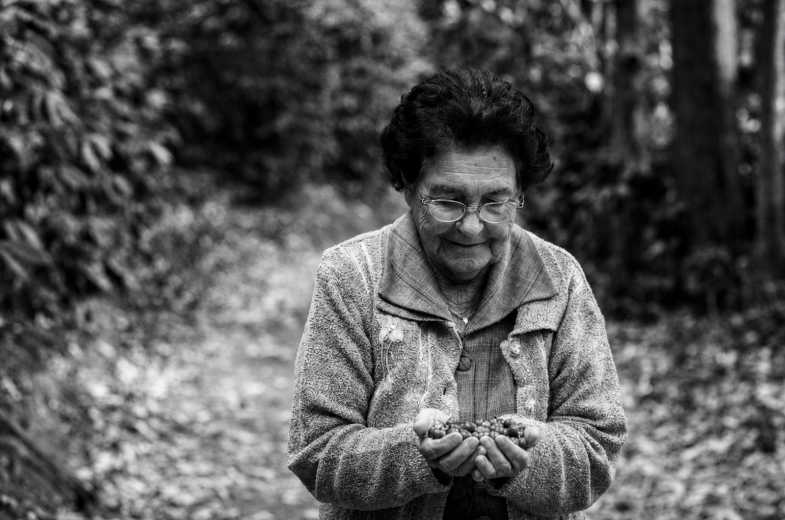 Dona Ceci com frutos de café na Fazenda Santa Catarina